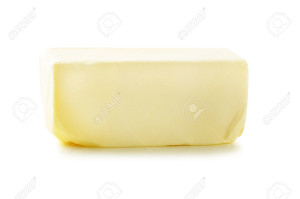 Stick of butter, cut, isolated on white.